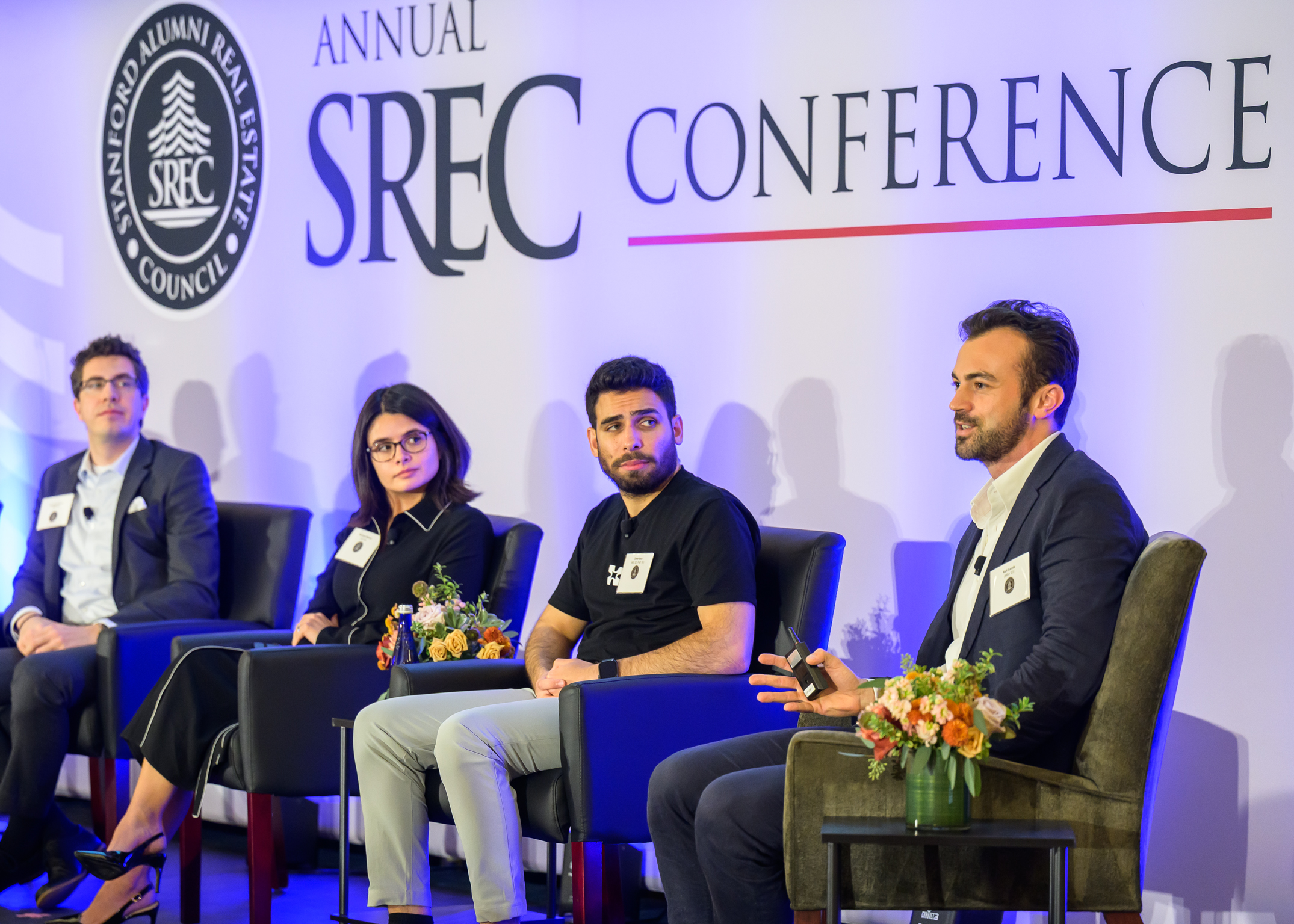 Prior SSIF grantees Alexander Michalatos (MBA '23), Maryssa Barron (JD '24), Omar Issa (MS ‘22, PhD ’24), and Rafi Sands (MBA '23) speak at the 2025 SREC Fall Conference.
